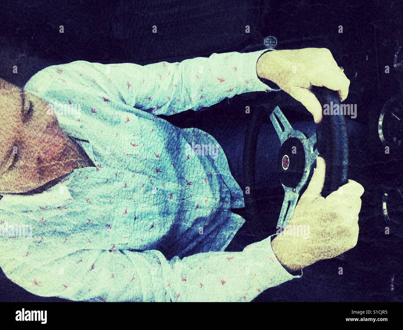 Elevato angolo di visione della donna alla guida di un 1973 MGB roadster, le mani sul volante. Foto Stock