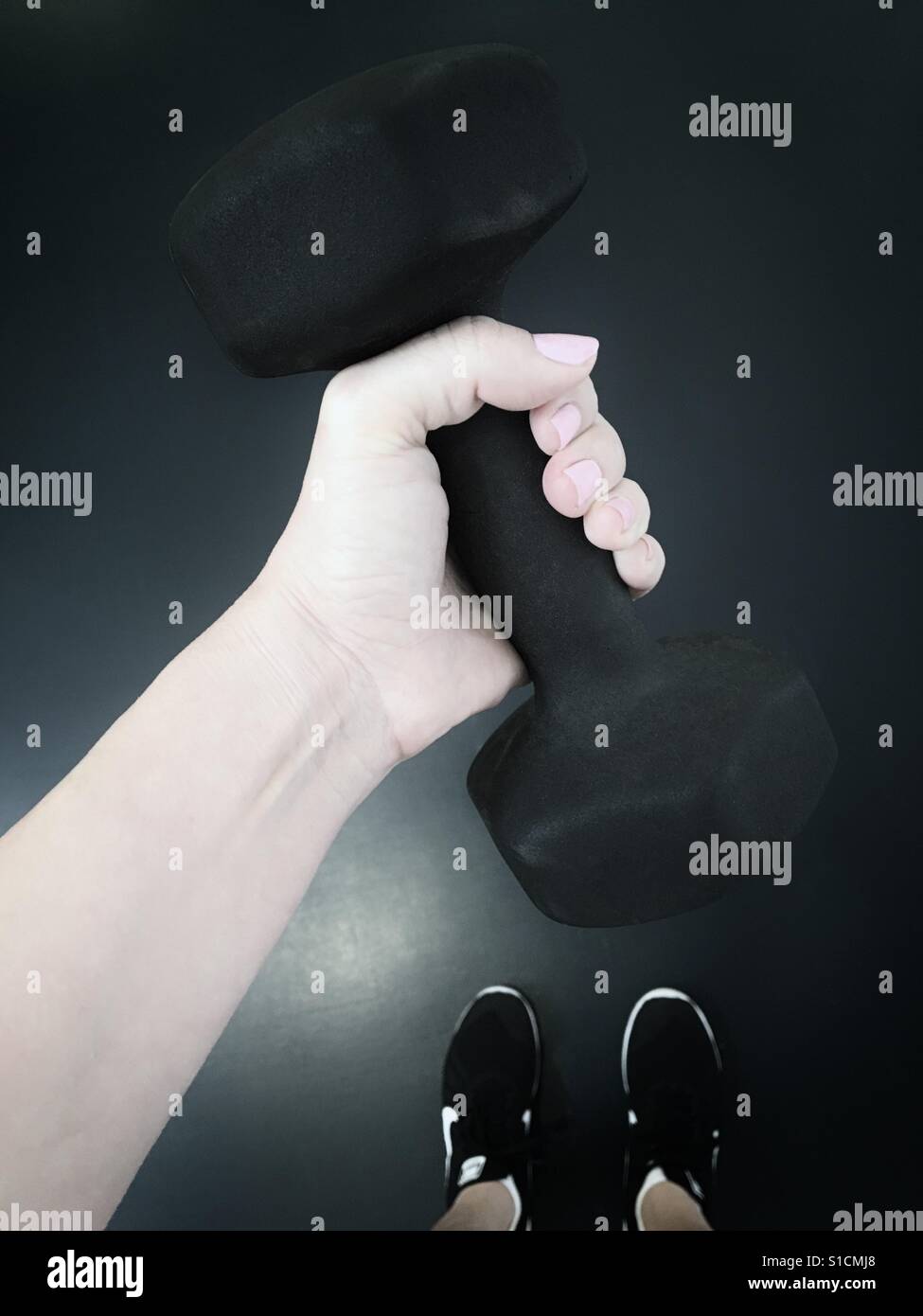 Donna che mantiene il peso a mano Foto Stock
