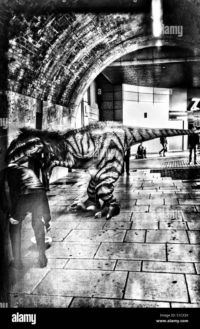 Attore vestito come un dinosauro nel tunnel, Londra - Immagine stock catturata con smartphone