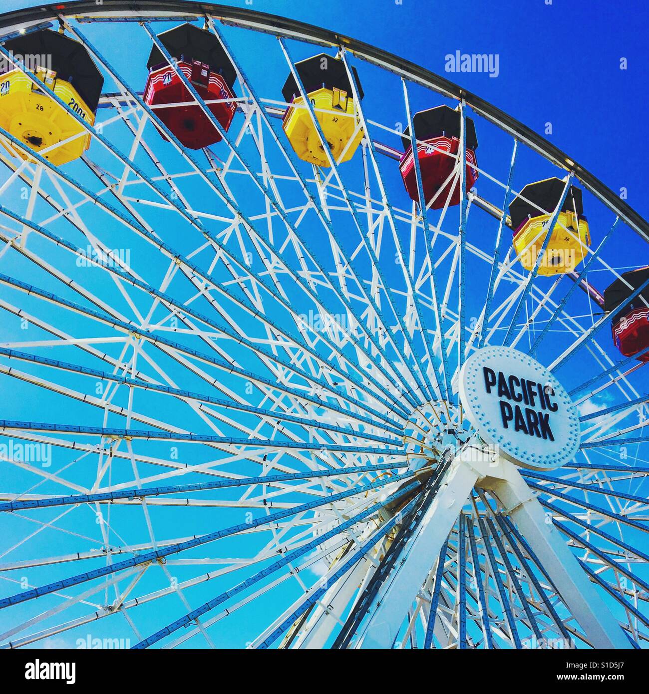 Ruota panoramica sul molo di Santa Monica con il rosso e il giallo cabine e cielo blu sullo sfondo. - Immagine stock catturata con smartphone