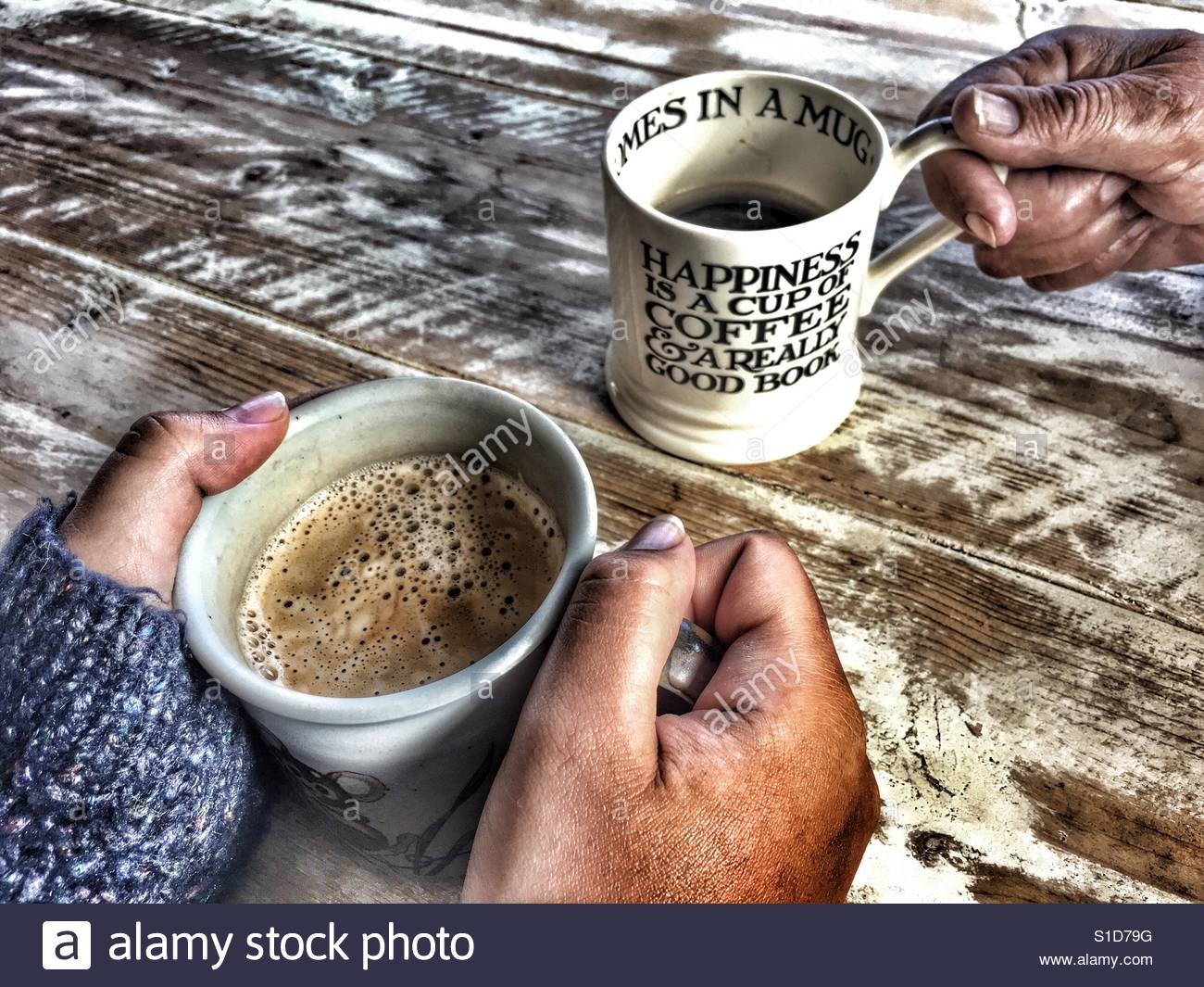 Due persone aventi il caffè, close up di tazze e le mani sul tavolo Foto Stock