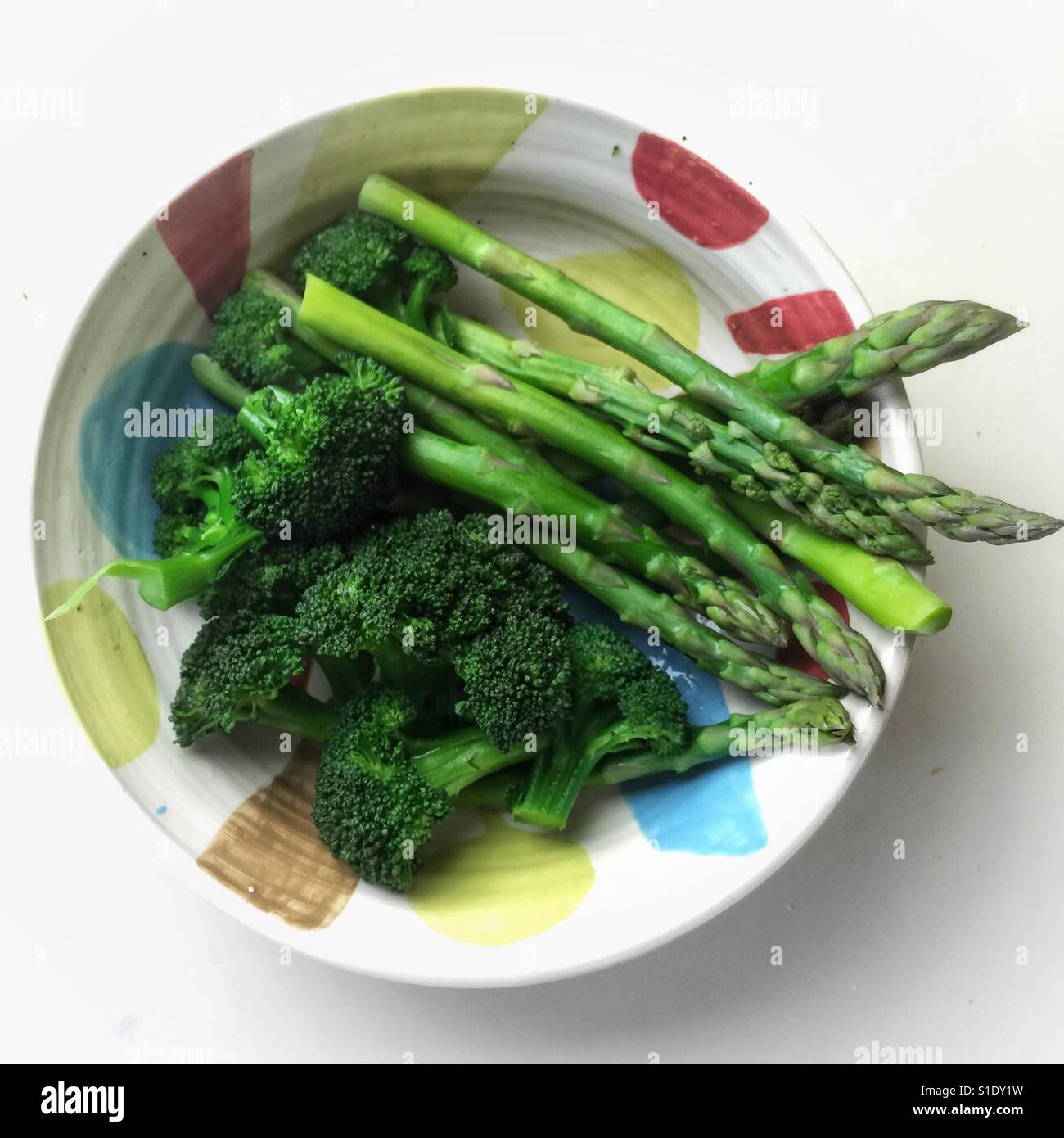 Gli asparagi cotti al vapore e broccoli in fatti a mano la coppa in ceramica - Immagine stock catturata con smartphone