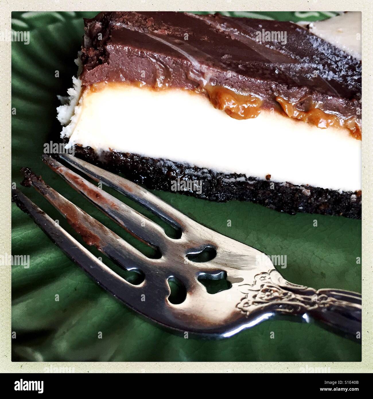Torta di formaggio sulla piastra verde con forca - Immagine stock catturata con smartphone