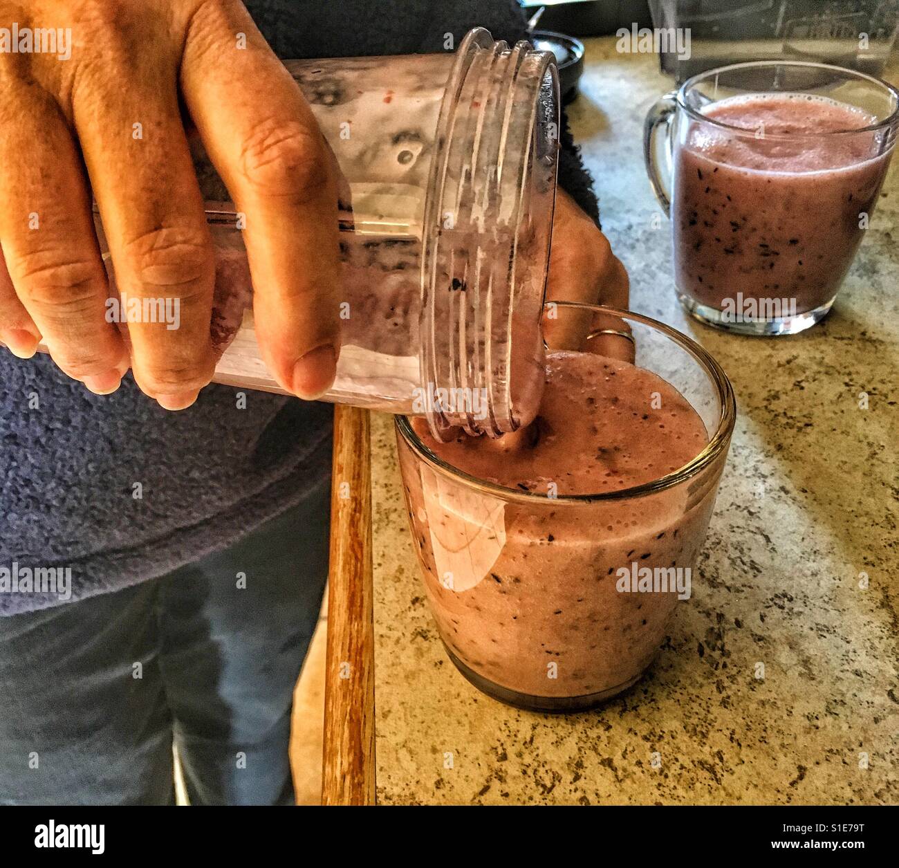 Uno stile di vita sano. Donna preparare in casa frullati di frutta per colazione. Foto Stock