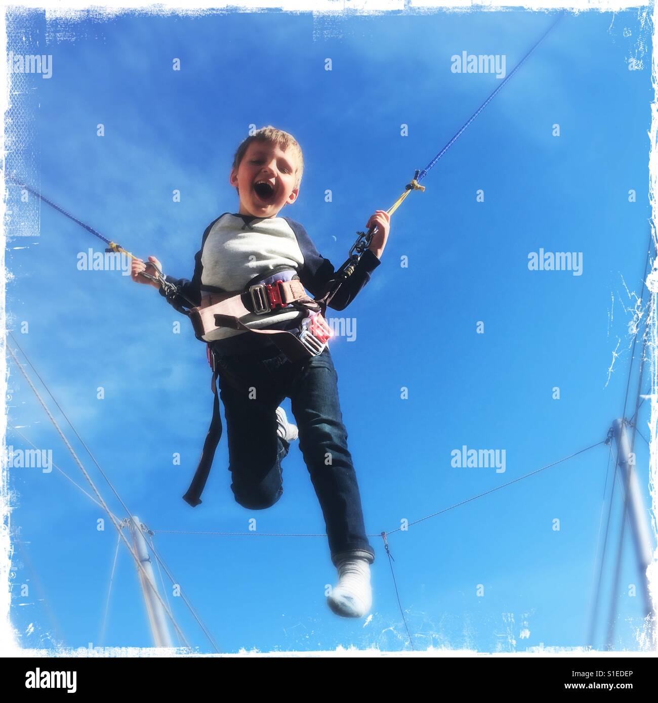 Ragazzo giovane avendo divertimento rimbalza su un trampolino Foto Stock