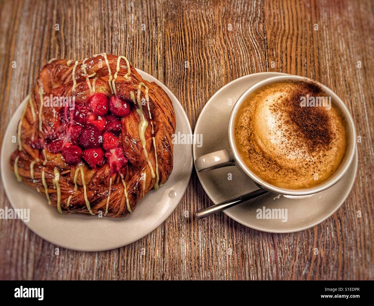 Il Cappuccino e lampone torta sul tavolo - Immagine stock catturata con smartphone