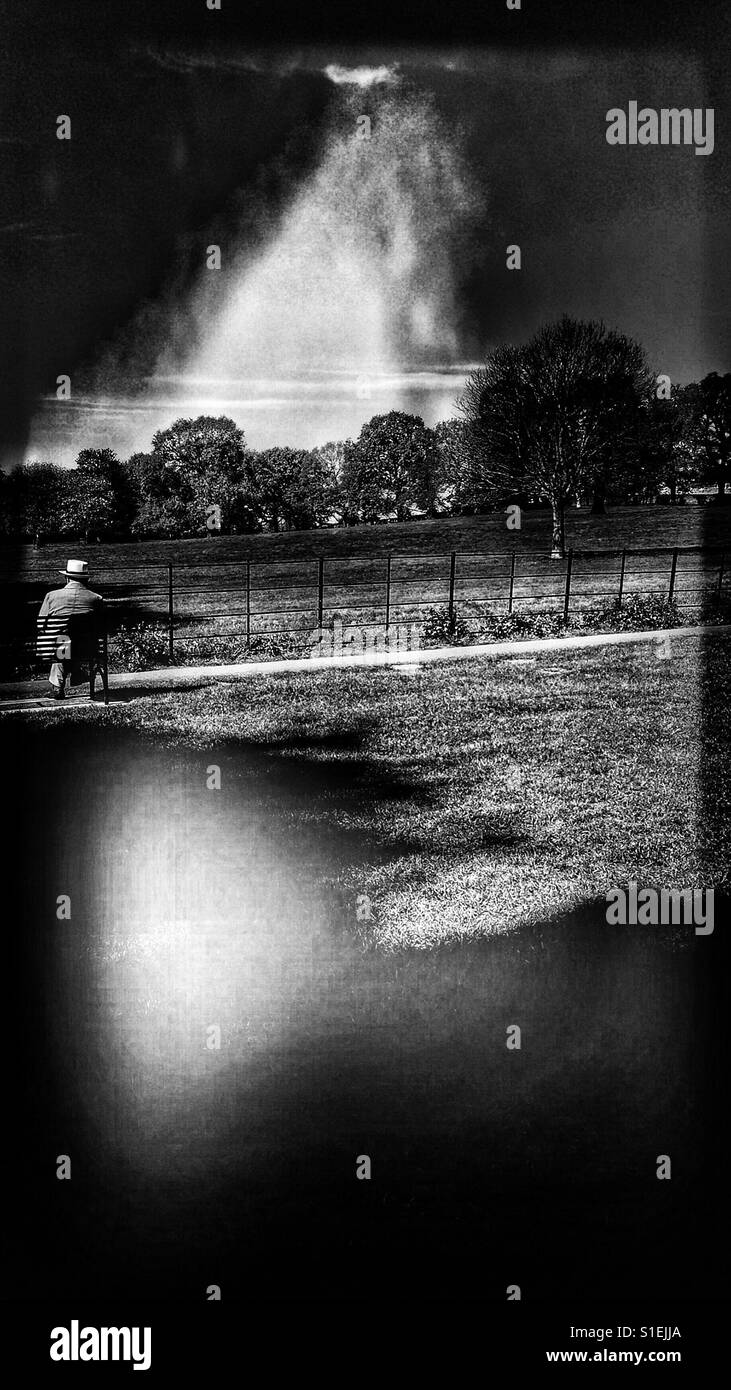 Uomo in hat seduto da solo in posizione di parcheggio Foto Stock