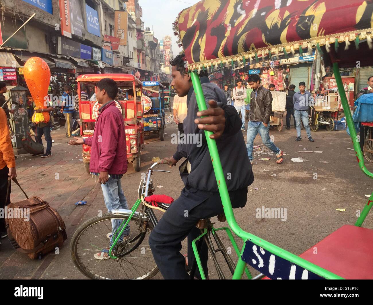 In rickshaw driver attendere per passeggeri in Paharganj, Delhi in India - Immagine stock catturata con smartphone