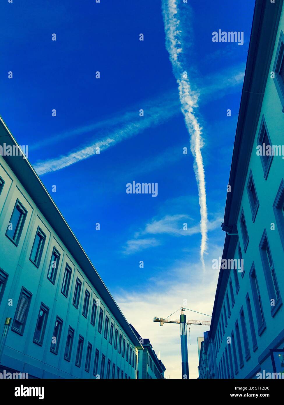 Una strada a Karlsruhe in Germania con gru e una croce bianca piano sentieri nel cielo Foto Stock