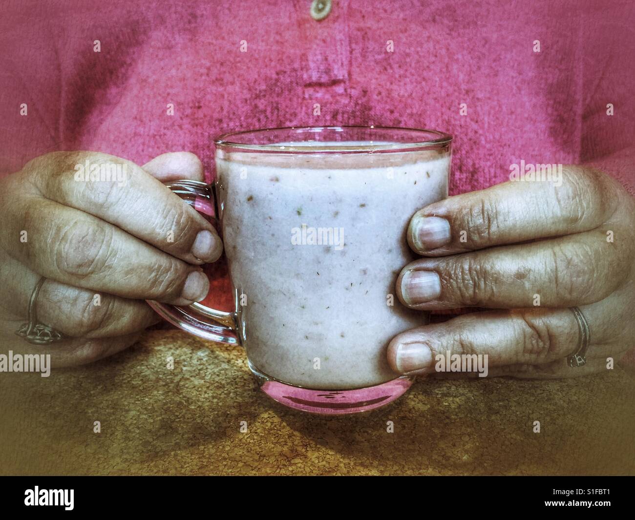 La donna in rosa di contenimento di vetro rosa fresca frullato di frutta - Immagine stock catturata con smartphone