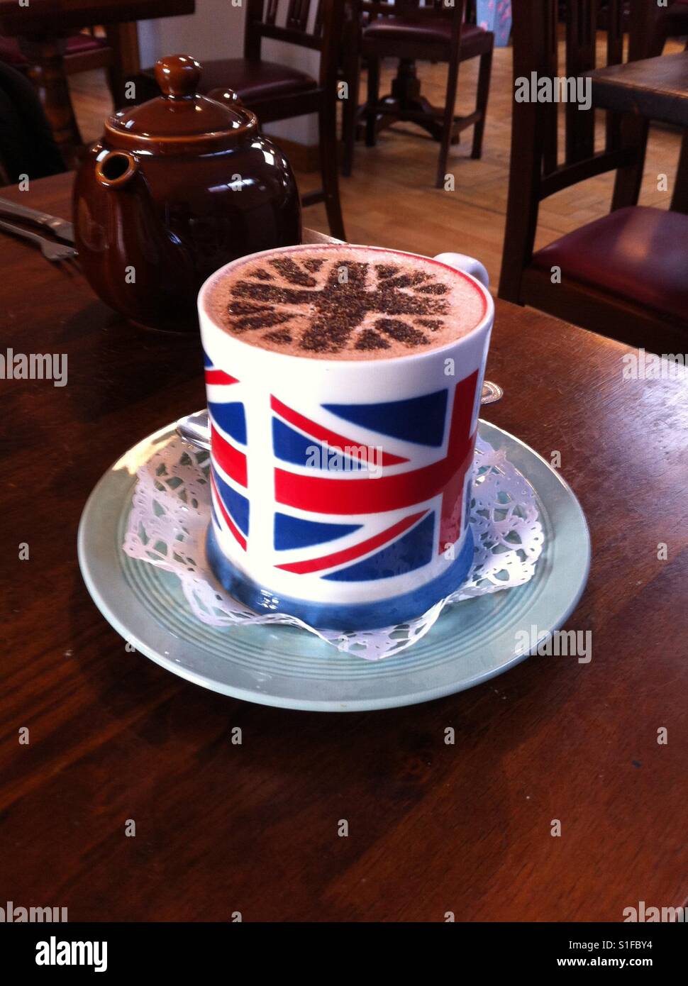 Cioccolata calda servita in una Unione Jack mug con ulteriore simbolo sulla parte superiore della bevanda. Foto Stock