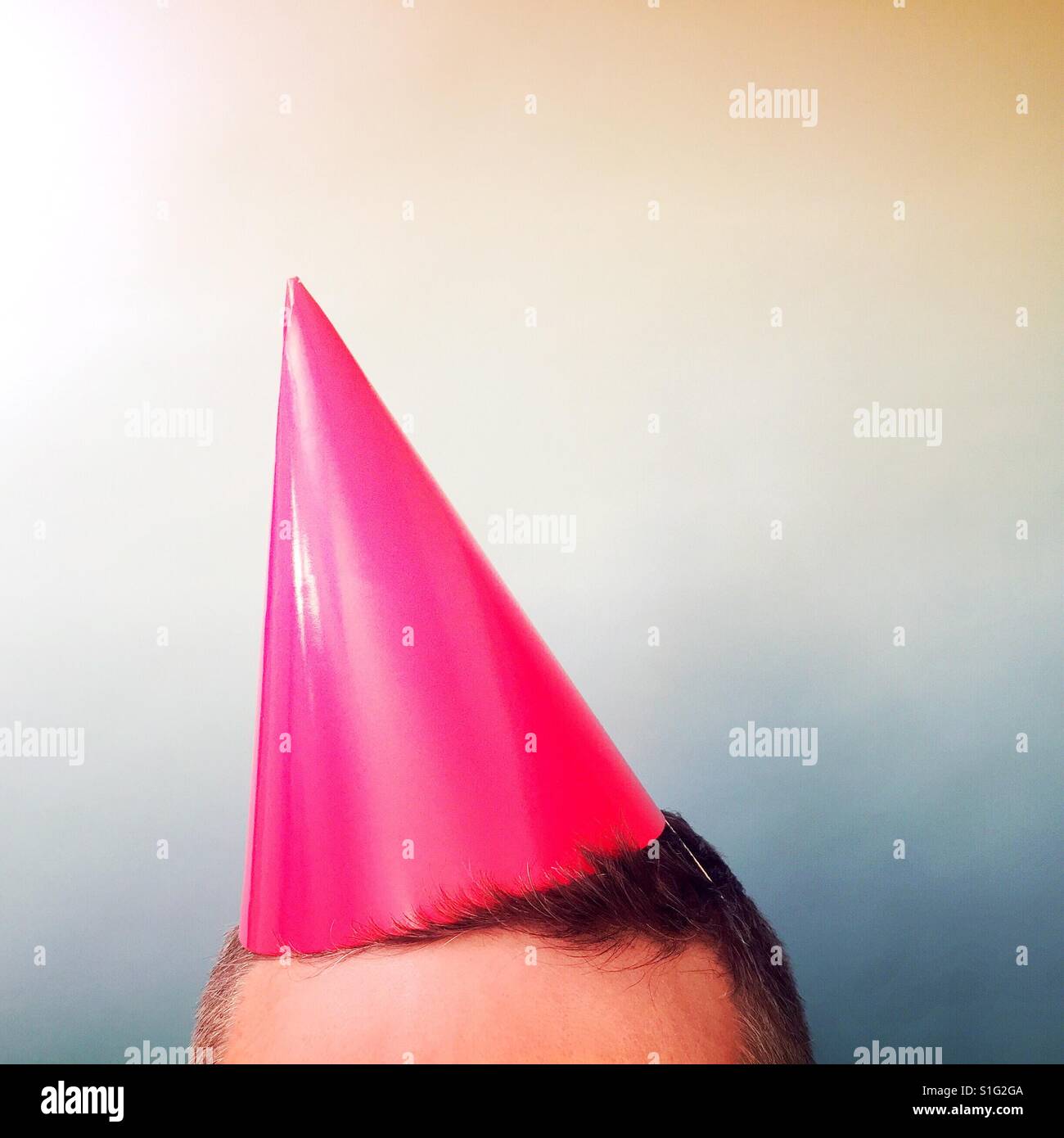 Un colpo ritagliata che mostra solo il fronte di un maschio maturo indossando un cappello di partito Foto Stock
