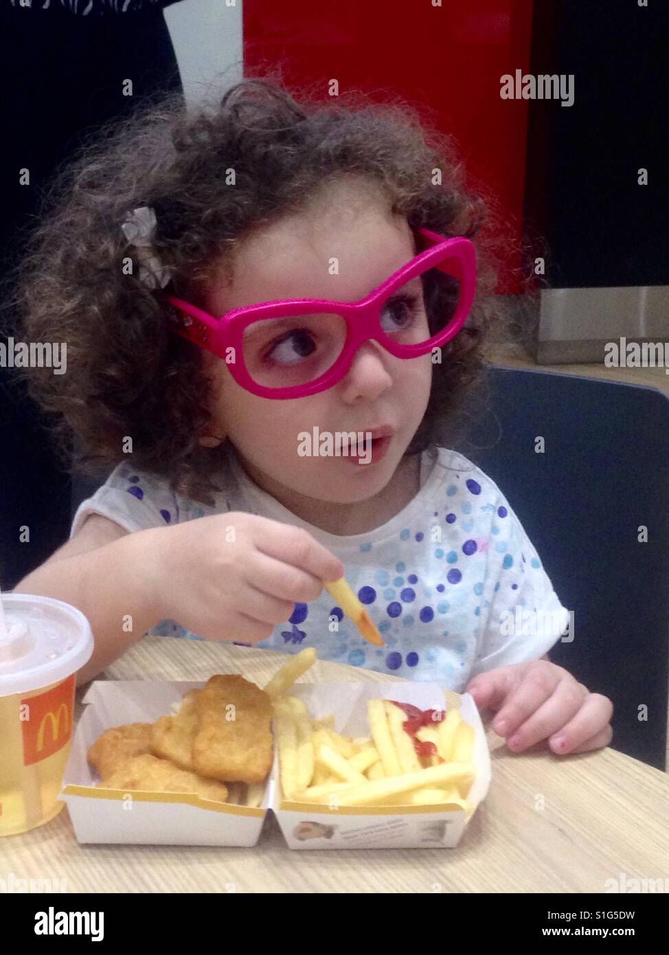 Bambina mangiare McDonalds Foto Stock