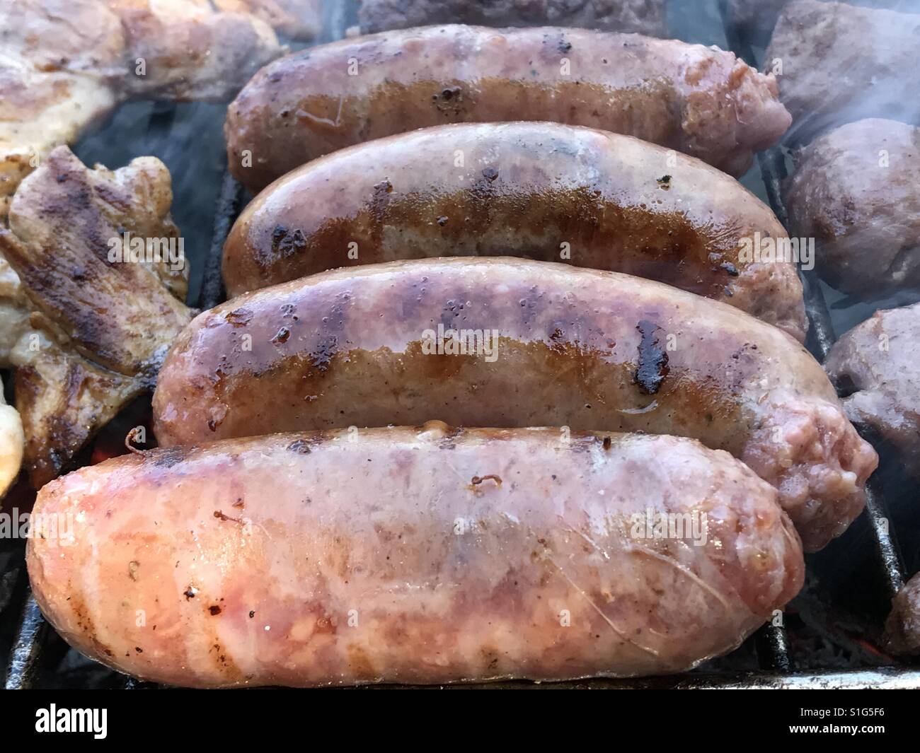 Salsicce italiane su un grill Foto Stock