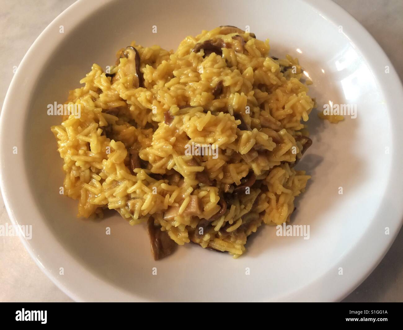 Funghi e risotto allo zafferano. - Immagine stock catturata con smartphone