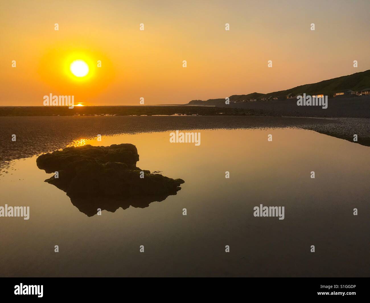 Un tramonto di maggio sulla spiaggia braystones guardando dritto verso il sole - Immagine stock catturata con smartphone