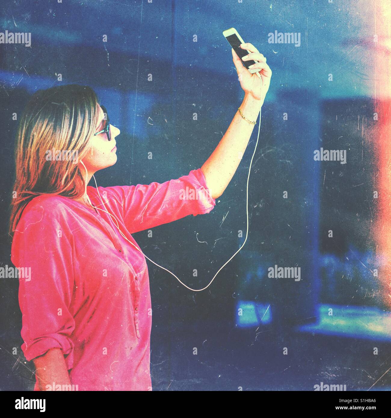 Giovane donna utilizza lo smartphone facendo una chat video o selfie - Immagine stock catturata con smartphone