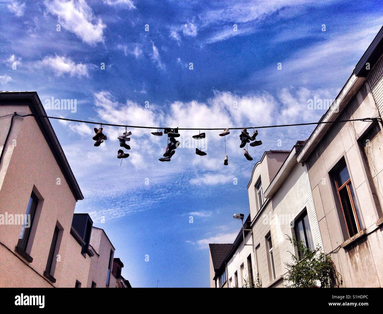 Vecchio sneakers appeso su una linea Foto Stock