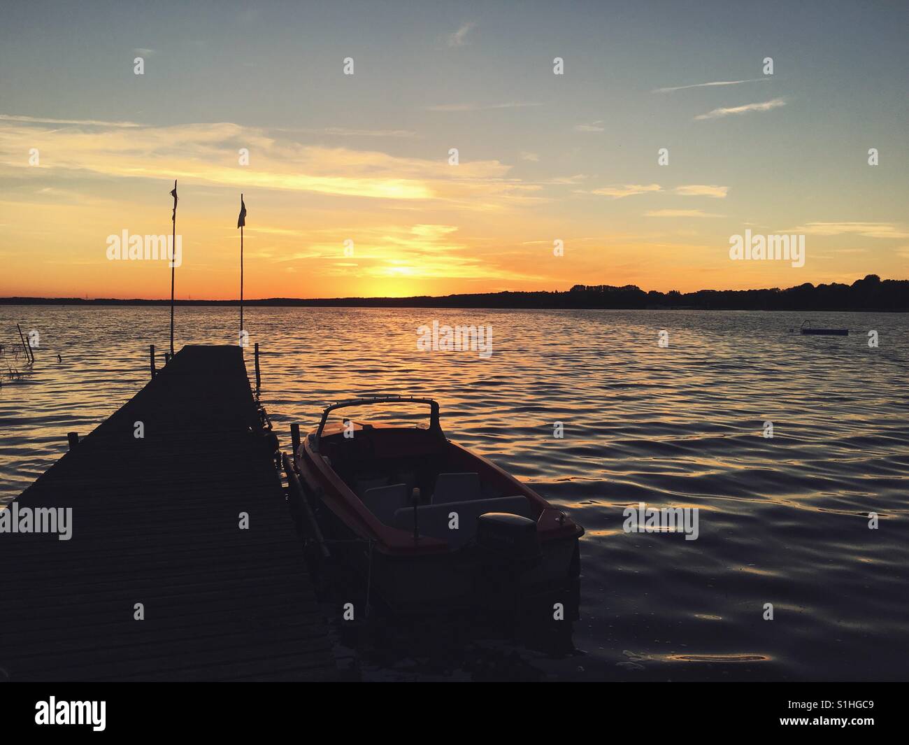 Una barca su un molo al tramonto - Immagine stock catturata con smartphone