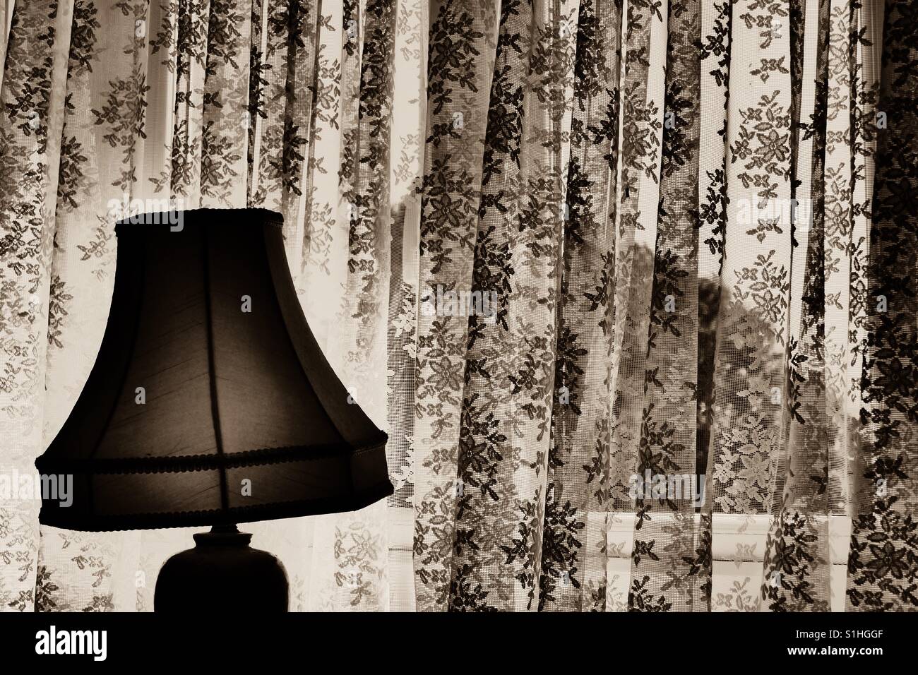 Vecchio sfondo della lampada di guardare attraverso una finestra in seppia. Foto Stock