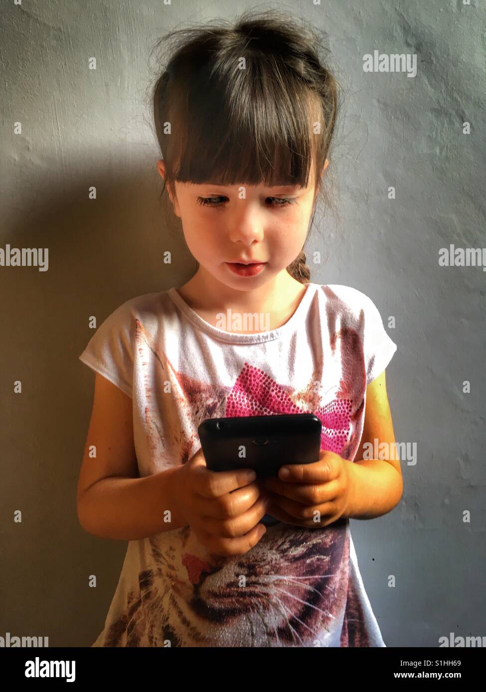 5 anno vecchia ragazza con smart phone - Immagine stock catturata con smartphone