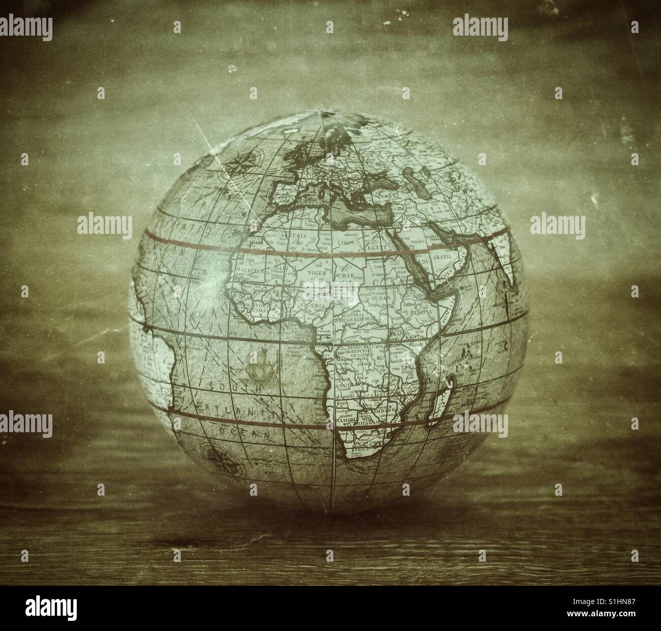 Un vecchio, olde Globo mondo del mondo con una texture vintage su uno sfondo semplice. - Immagine stock catturata con smartphone