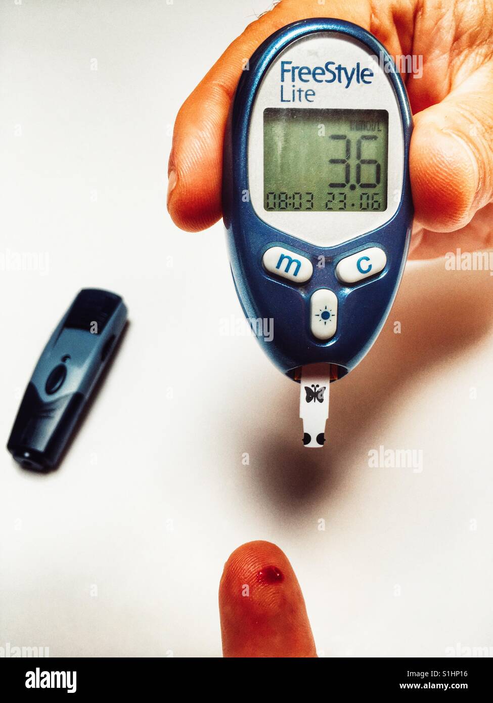 Il livello di glucosio nel sangue il monitor mostra una lettura di 3.6 di un paziente diabetico - Immagine stock catturata con smartphone