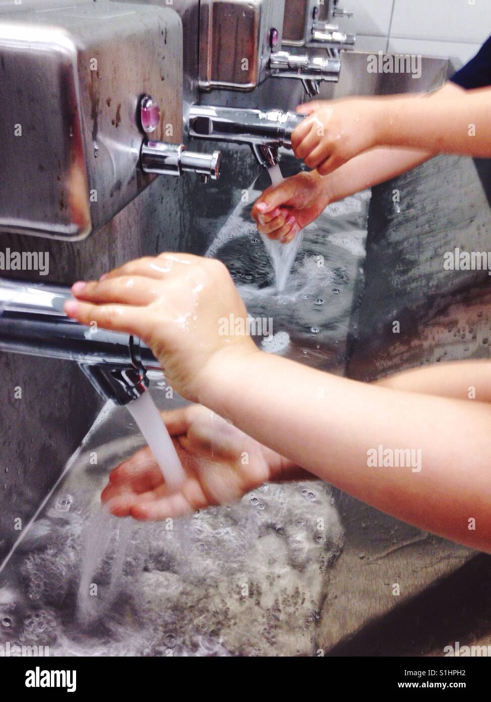I bambini lavarsi le mani. - Immagine stock catturata con smartphone