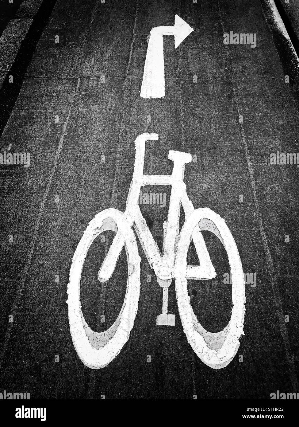 Un dipinto di bianco simbolo di una bicicletta in una zona urbana - si tratta di un ciclo dedicato lane. La freccia indica i ciclisti devono girare a destra fino a venire. Credito foto - © COLIN HOSKINS. - Immagine stock catturata con smartphone