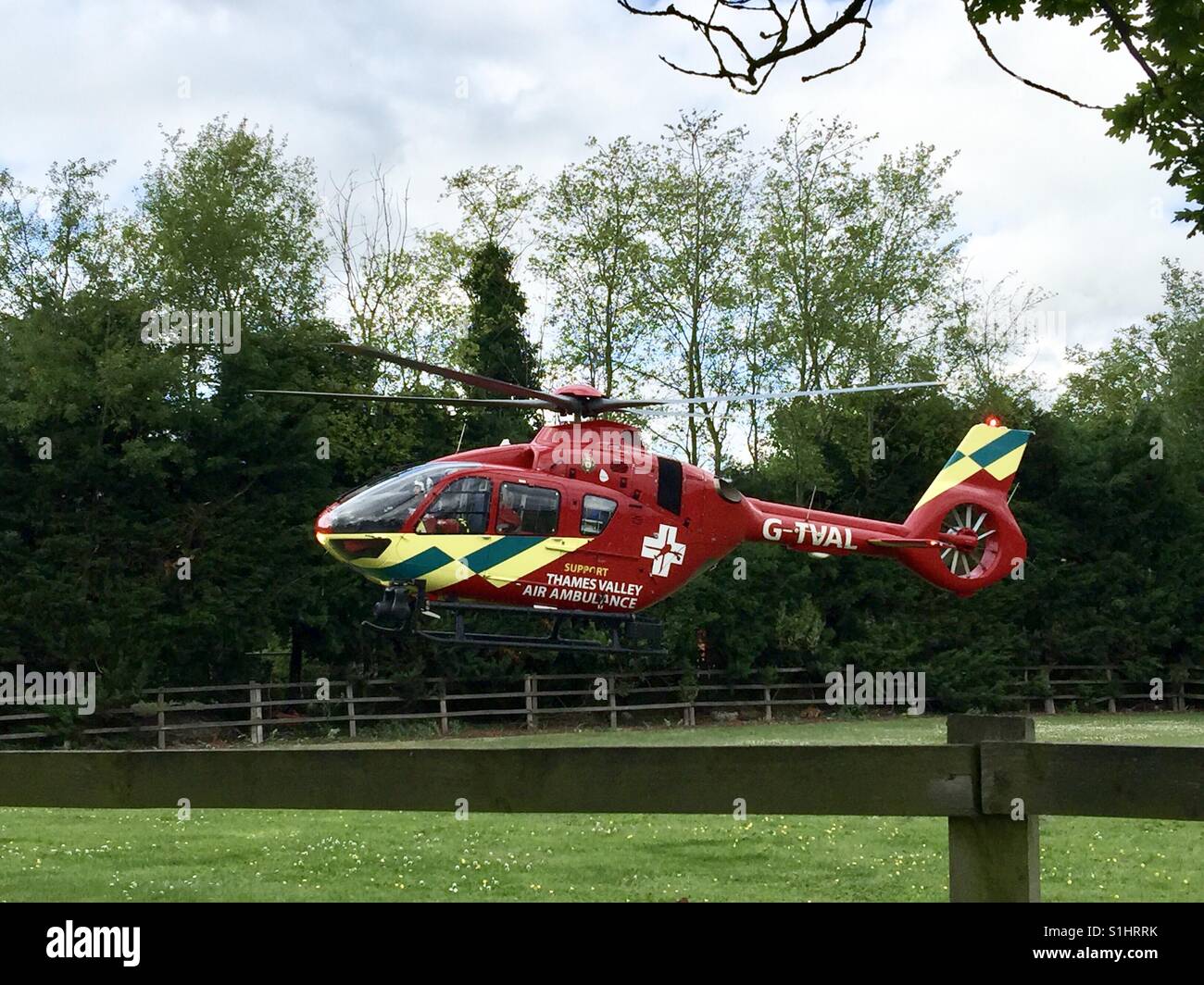 La Thames Valley Air Ambulance terre in un campo di Oxfordshire per il trasporto di un ferito in ospedale. Foto Stock