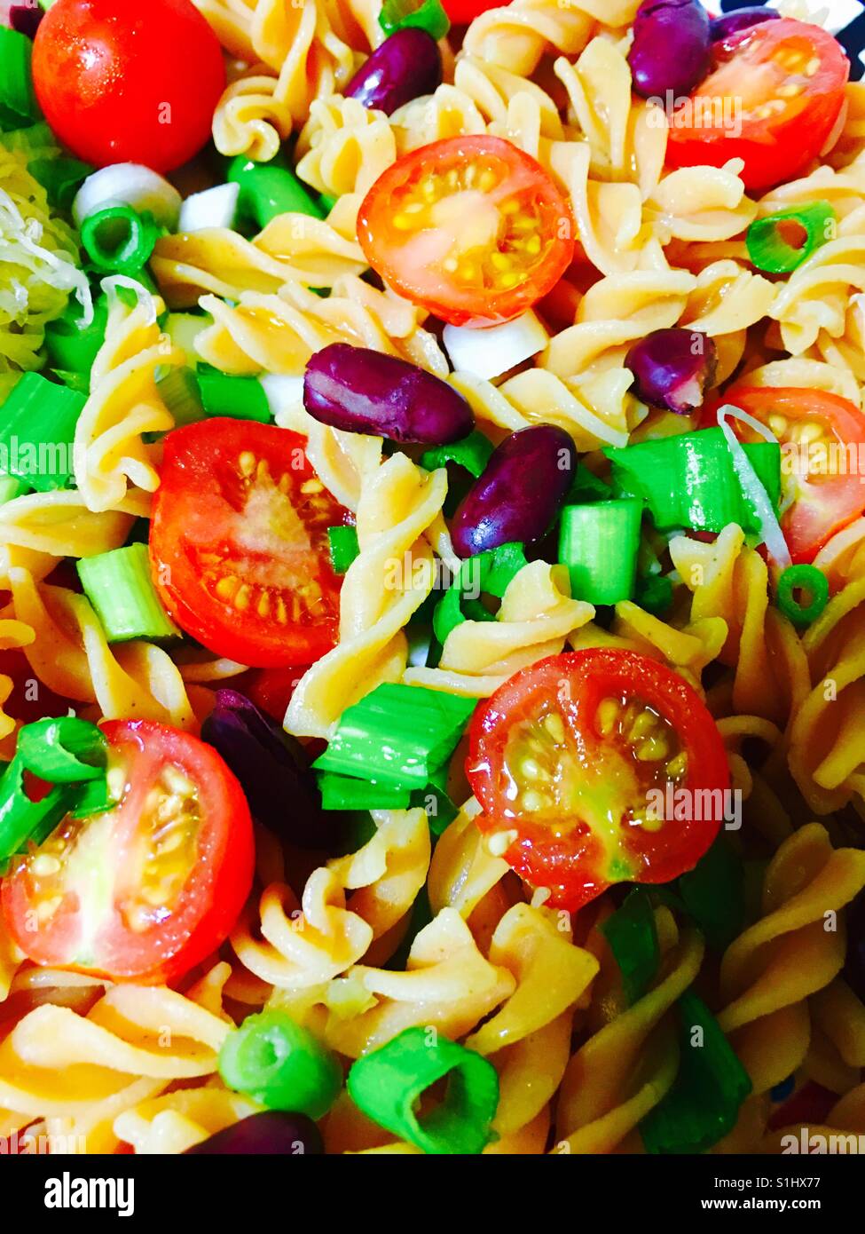 Spirale di lenticchie fusilli con pomodori ciliegia cipolline e fagioli rossi - Immagine stock catturata con smartphone