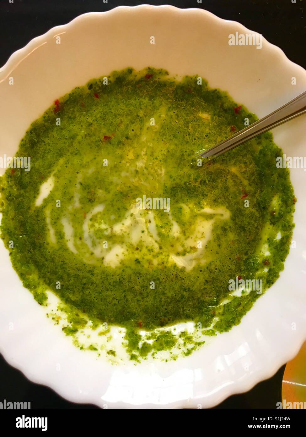 Laghetto Verde di miscele di Menta, foglie di coriandolo e peperoncino con fluttuazioni di yogurt e pizzicato con sale & pepe Foto Stock