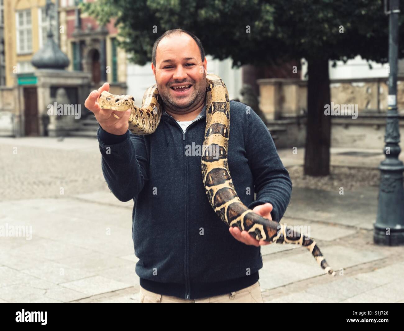 Uomo felice tiene in mano un serpente Foto Stock