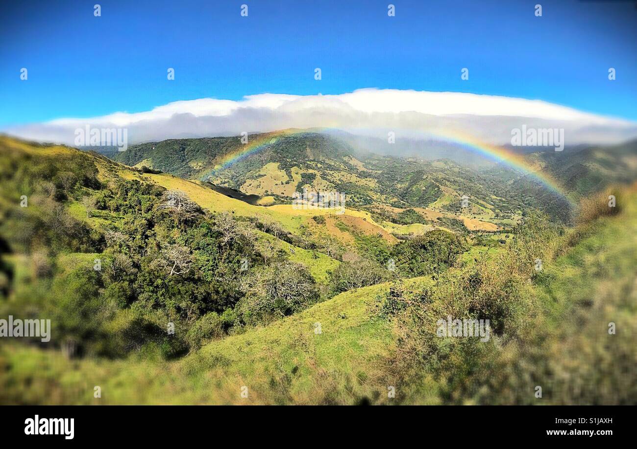Un arcobaleno si estende a valle in Puntarenas, Costa Rica. - Immagine stock catturata con smartphone