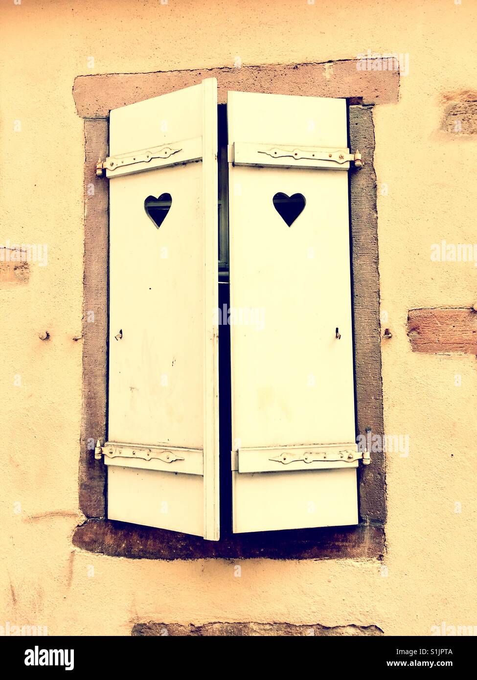 Il cuore forma su persiane pittoresche finestra su una casa in Francia perfetto esempio di Hygge (foto filtrata) Foto Stock