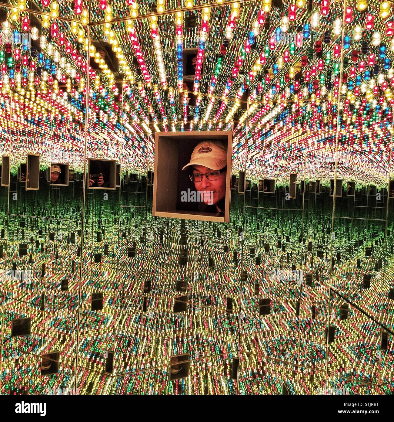 Uomo che guarda all'interno di una delle stanze speculari in corrispondenza di Yayoi Kusama in mostra a Seattle Art Museum Foto Stock