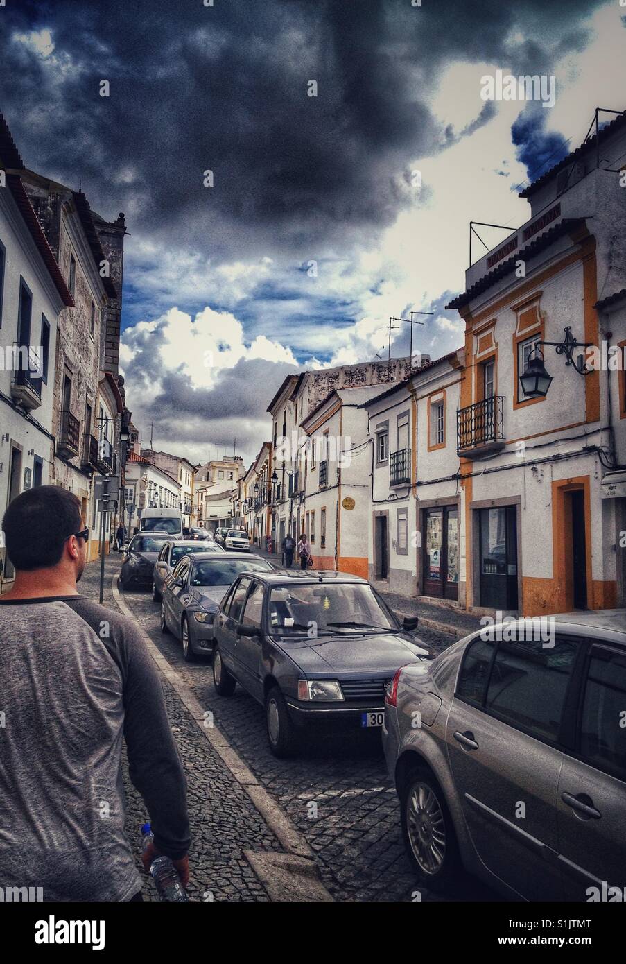 Uomo che cammina verso il basso street a Evora, Portogallo Foto Stock