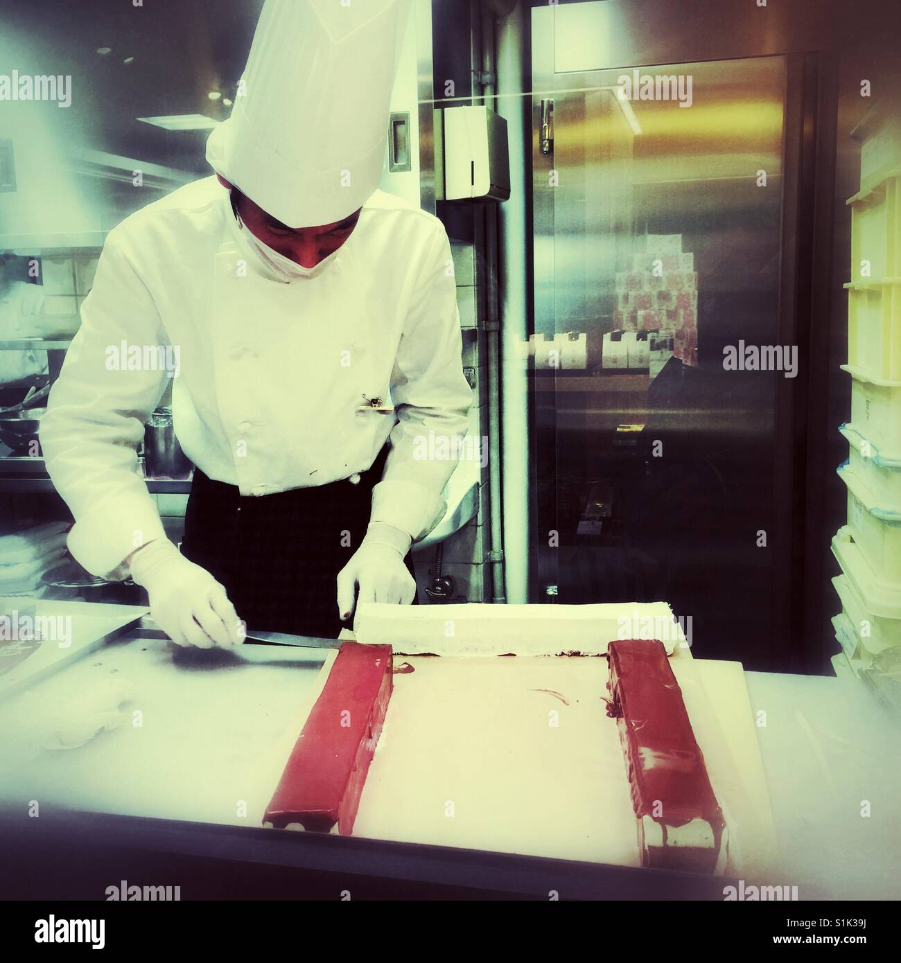 Pastry chef in uno dei Kyoto magazzini lavorando sulla torta di vetratura Foto Stock