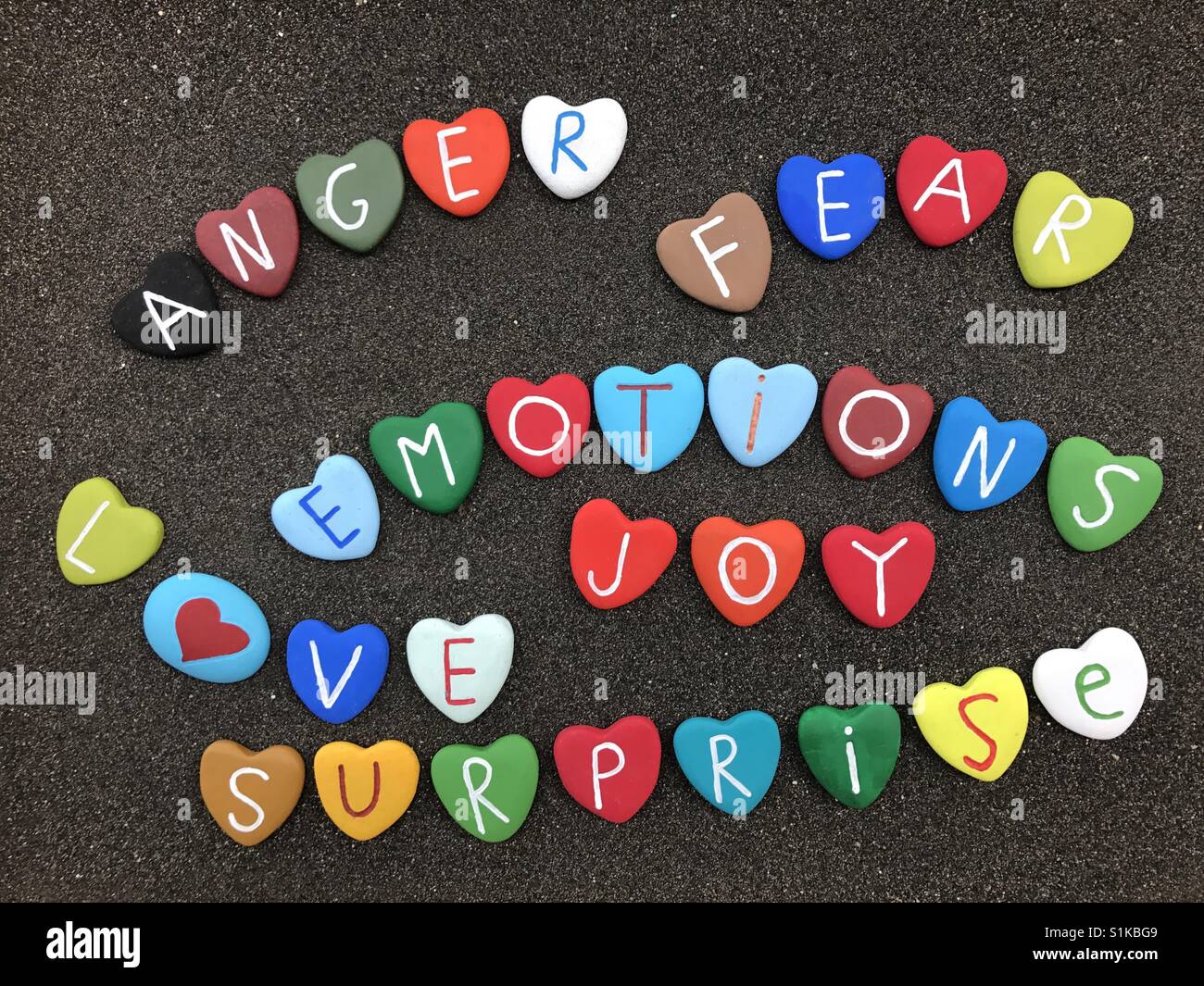 Emozioni parole colorate con pietre di cuore Foto Stock
