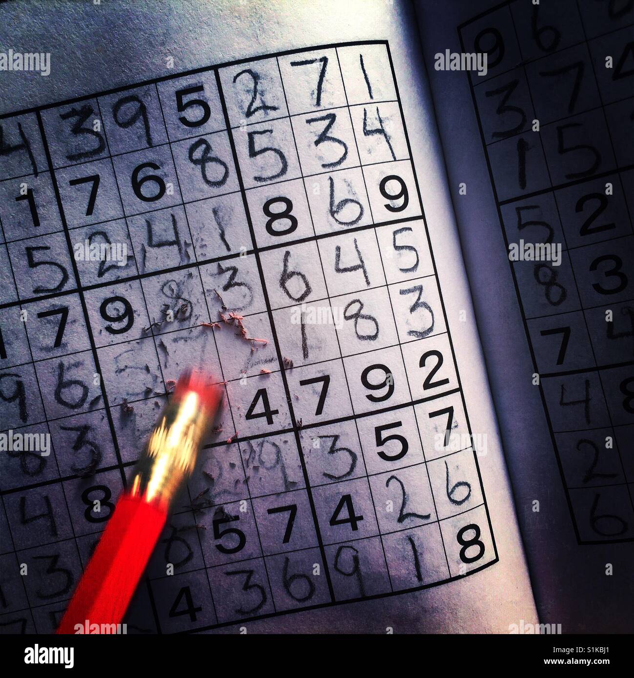 Un movimento sfocati per matita cancellando un errore commesso in un puzzle Sudoku Foto Stock