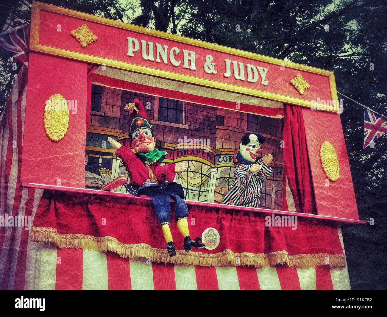 Un effetto retrò immagine di Joey il clown e Mr. Punch in Punch & Judy Show. Un uomo le prestazioni utilizzando vari burattini. Una infanzia preferito da tempi passati. Credito foto - © COLIN HOSKINS. Foto Stock