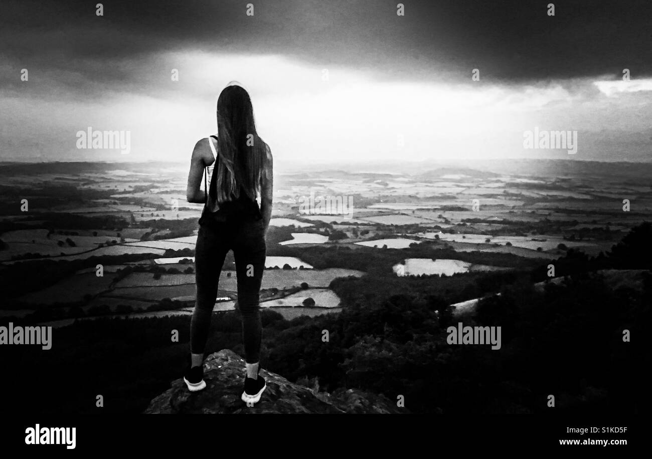 Giovane ragazza a guardare il tramonto e la vista panoramica dalla cima della collina Foto Stock