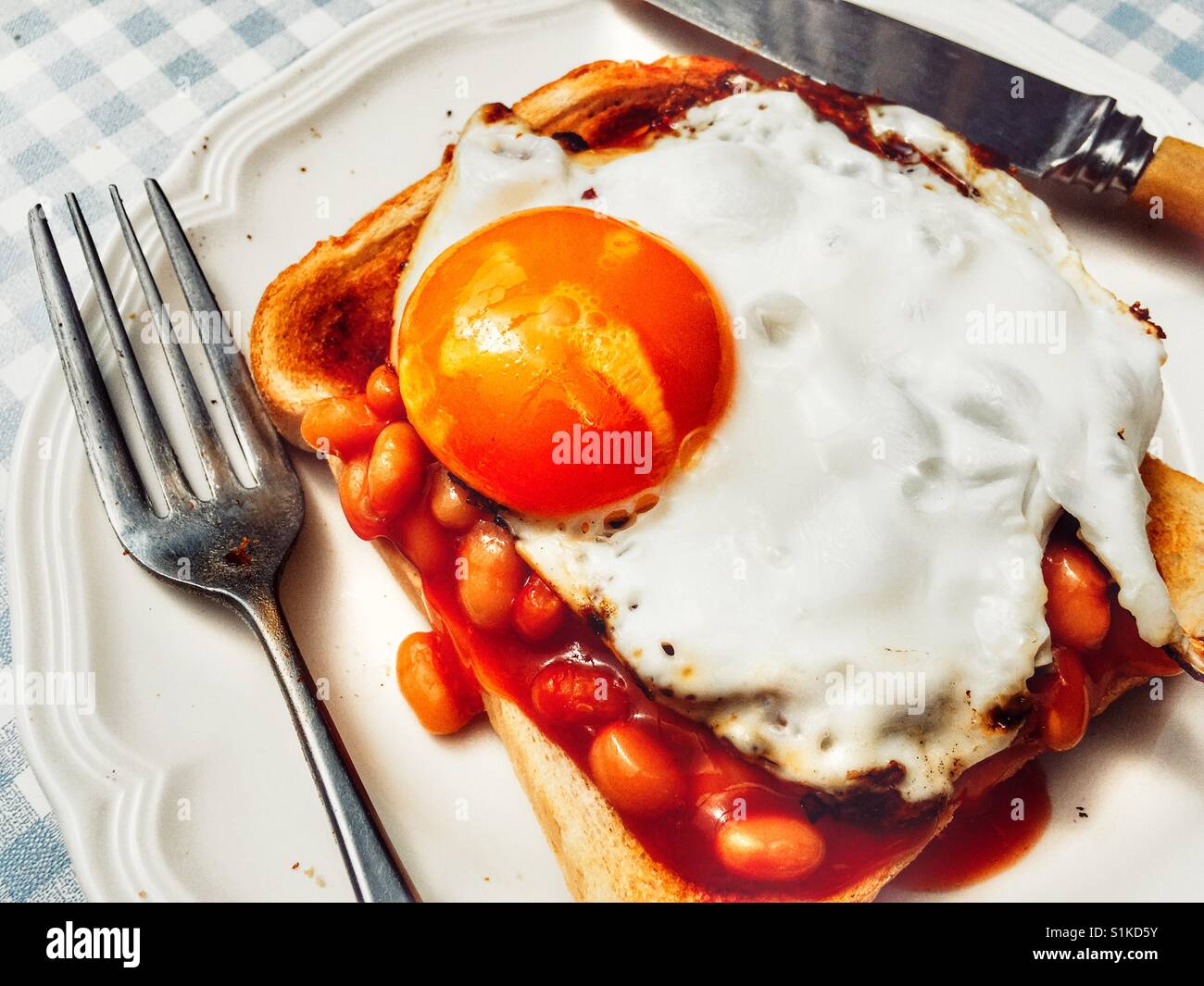 Heinz fagioli su pane tostato con uovo fritto Foto Stock