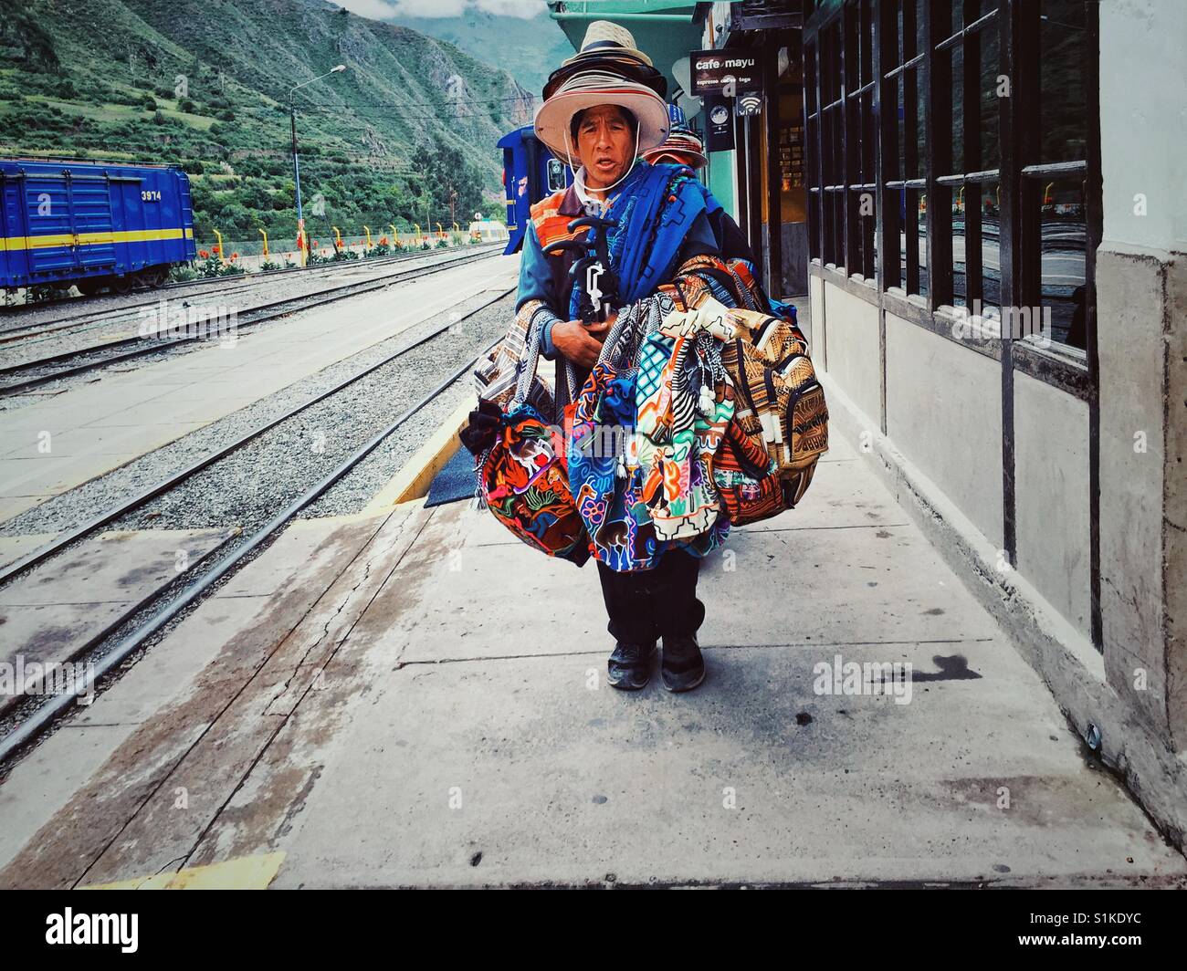 Tradizionale peruviana venditore tessile portando la sua merce su un treno dalla stazione di Ollantaytambo Foto Stock
