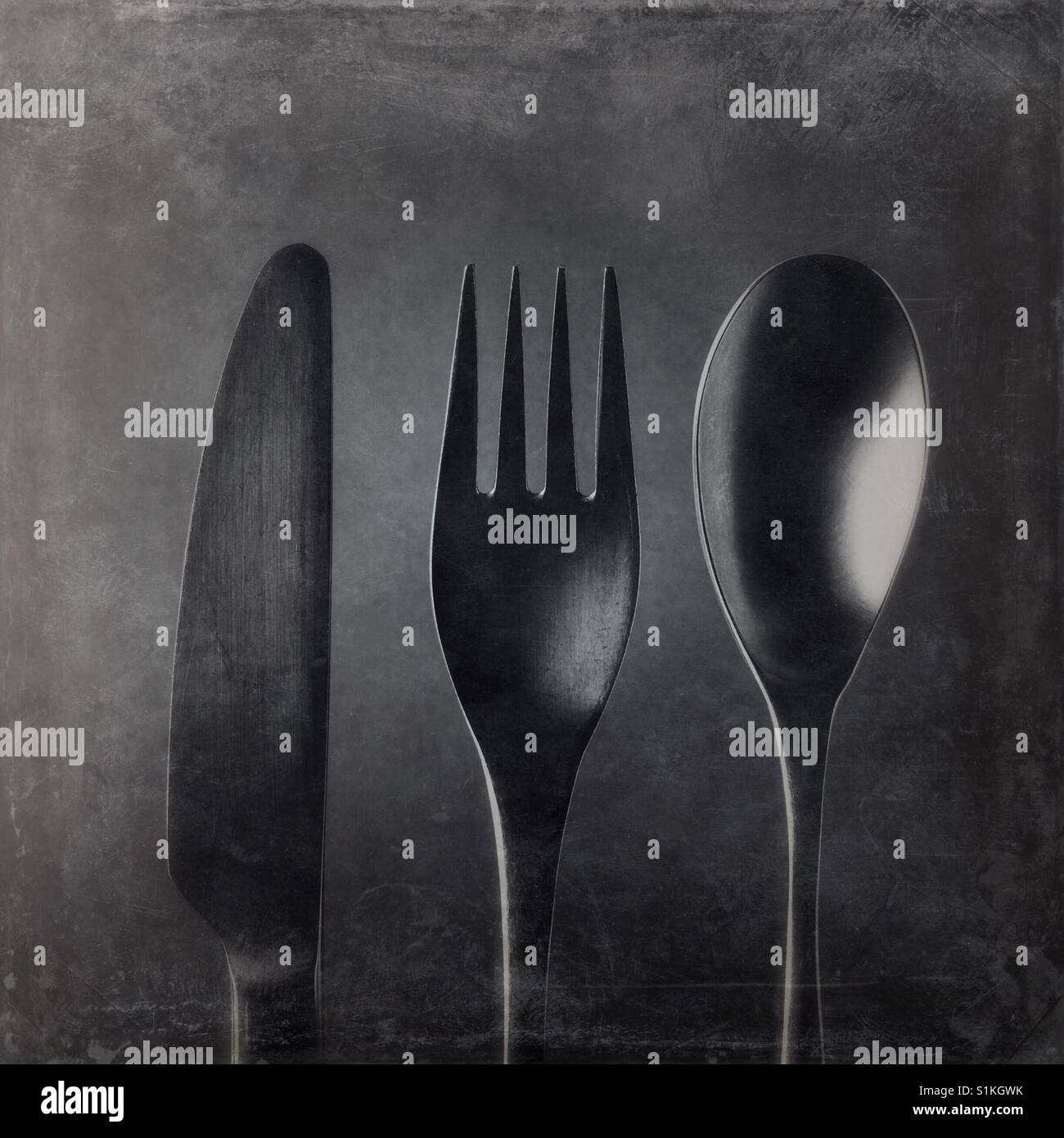 Un bianco e nero close up shot di overhead di un coltello e una forchetta e un cucchiaio Foto Stock