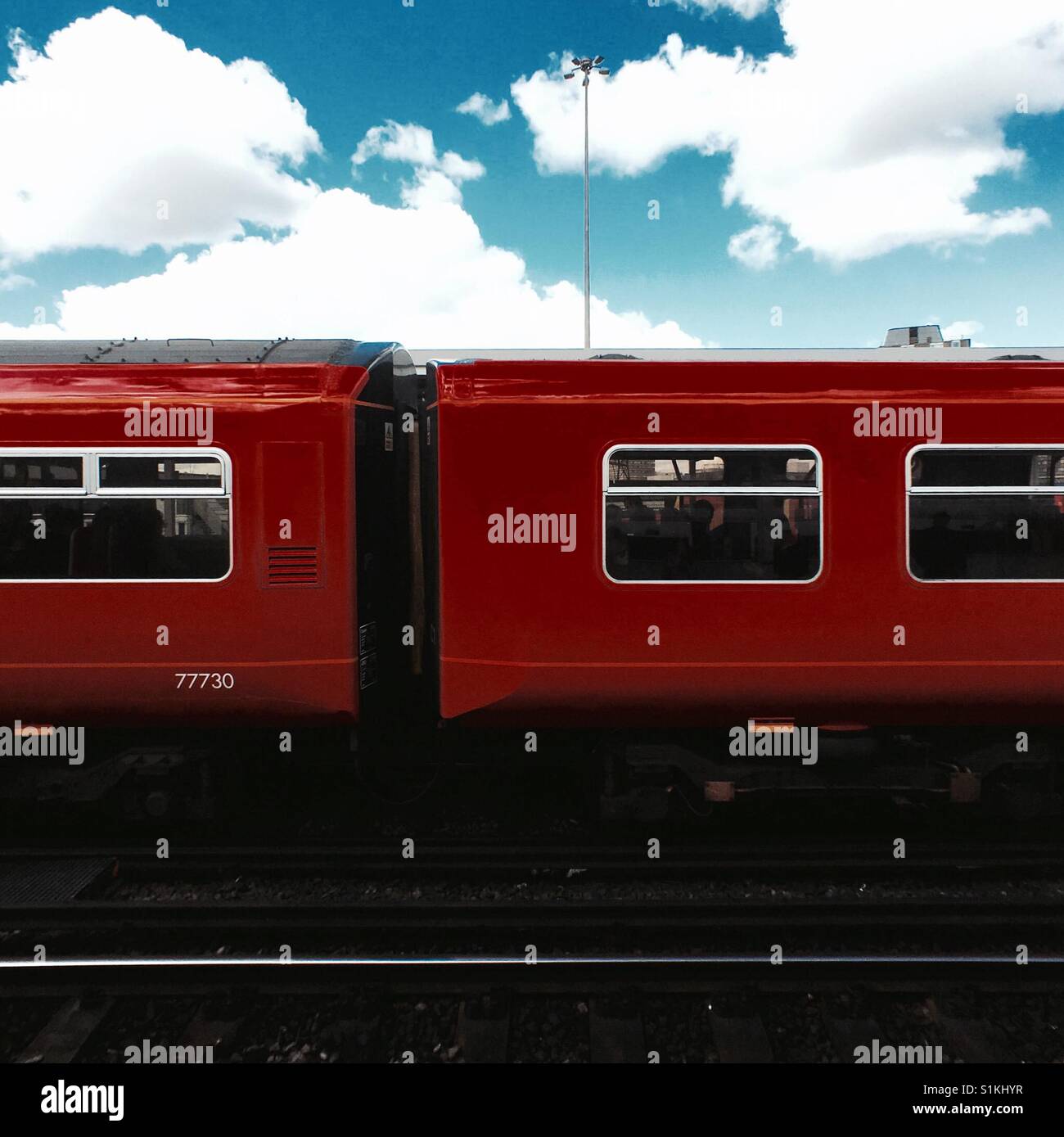 Graphic foto quadrata di rosso National Rail UK carrozze ferroviarie con cielo blu Foto Stock