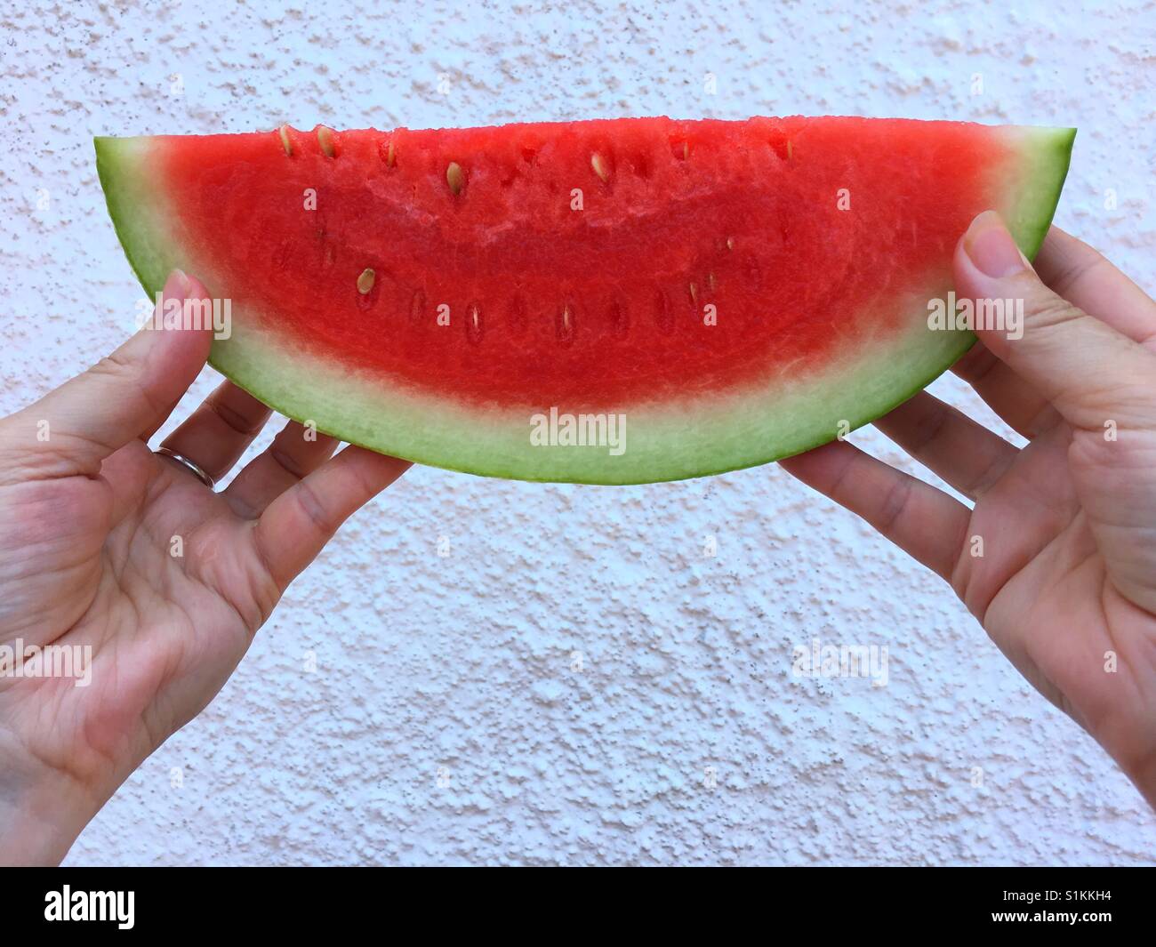 Donna che mantiene una fetta di cocomero - Immagine stock catturata con smartphone