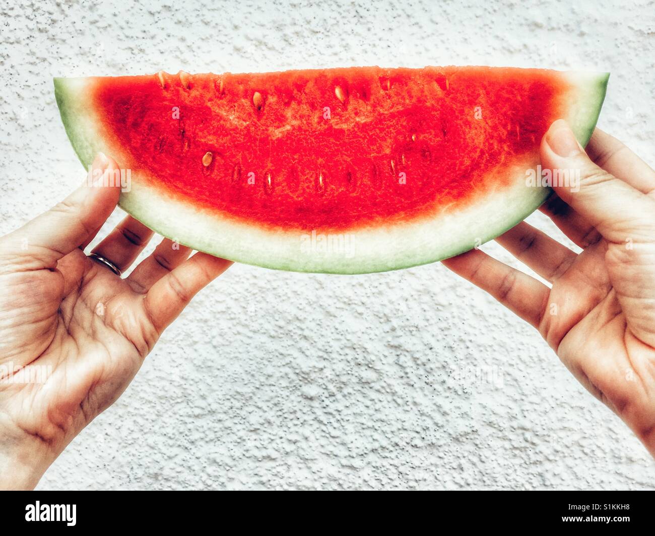 Donna che mantiene una fetta di cocomero - Immagine stock catturata con smartphone