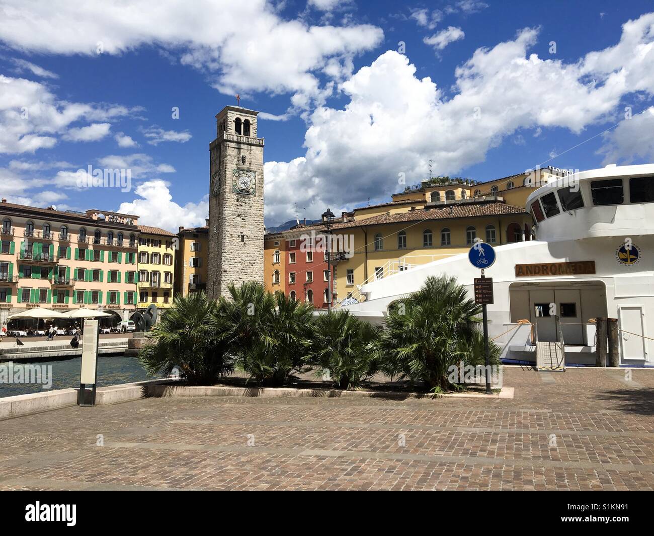 Riva del Garda sul Lago di Garda, Italy-May 2017: un traghetto è ormeggiata in banchina nel piccolo porto di fronte a piazza della città Foto Stock