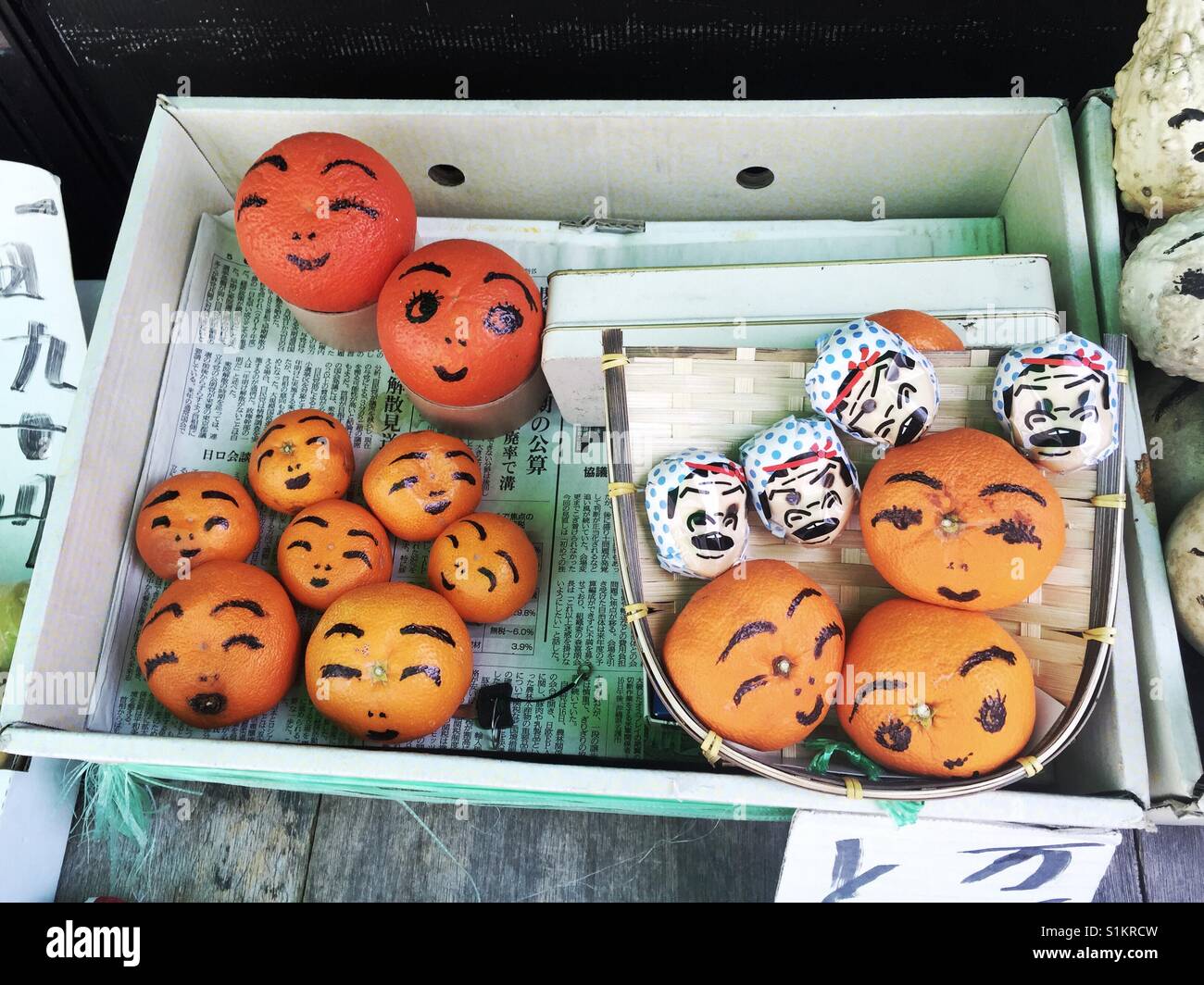 Arance Satsuma decorato con facce carine in vendita in Kyoto - Immagine stock catturata con smartphone